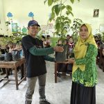 Kepala MI Salafiyah Ngalian, Ella Maryana, secara simbolis menyerahkan donasi bibit pohon kepada perwakilan Lintas Komunitas Peduli Pekalongan (LKPP) di Kecamatan Tirto, Kabupaten Pekalongan, Kamis (18/6/2026).